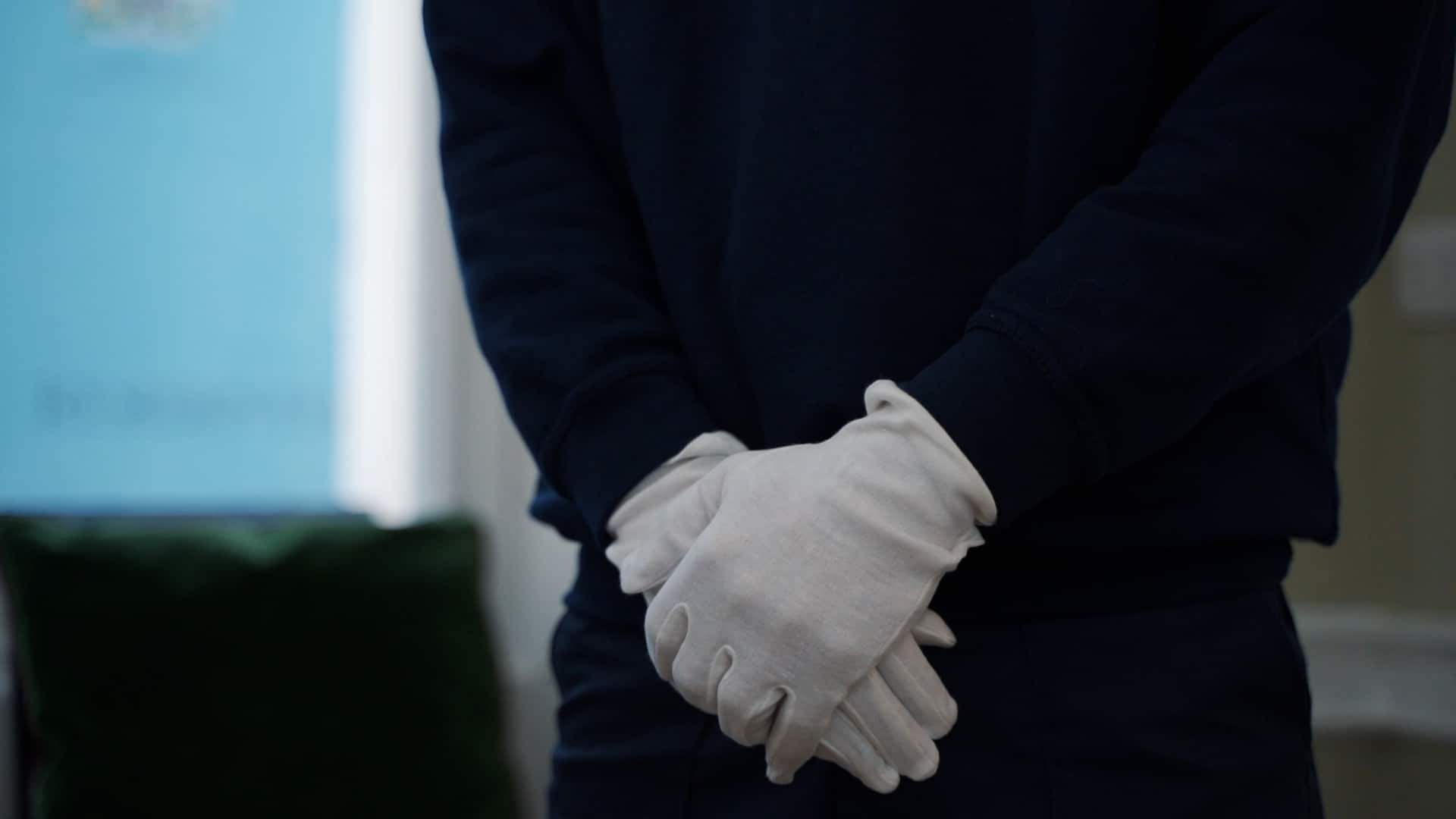 A man wearing white gloves, waiting for orders to know what needs to be done as part of his white-glove moving service.